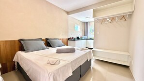 A bedroom with a bed, bedside table, and a mirror. - Your Home - Studios Boutique Hotel (Sao Luis)