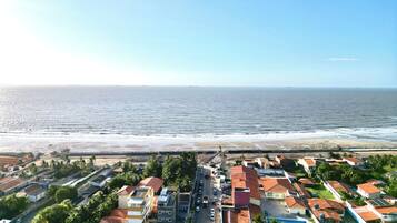 Una zona residencial costera con casas, una playa y una vista despejada del océano.