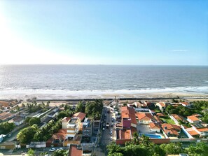 A coastal residential area with houses, a beach, and a clear view of the ocean.