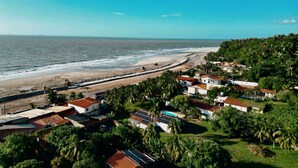 A coastal residential area with houses, a beach, and a rocky shoreline. - Your Home - Studios Boutique Hotel (Sao Luis)