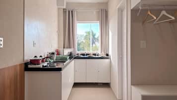 Cocina moderna con ventana, armarios y encimera con diversos objetos.