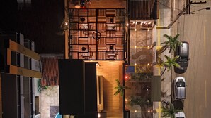 An aerial view of a hotel with a pool, a wooden deck, and a parking area with cars. - Your Home - Studios Boutique Hotel (Sao Luis)