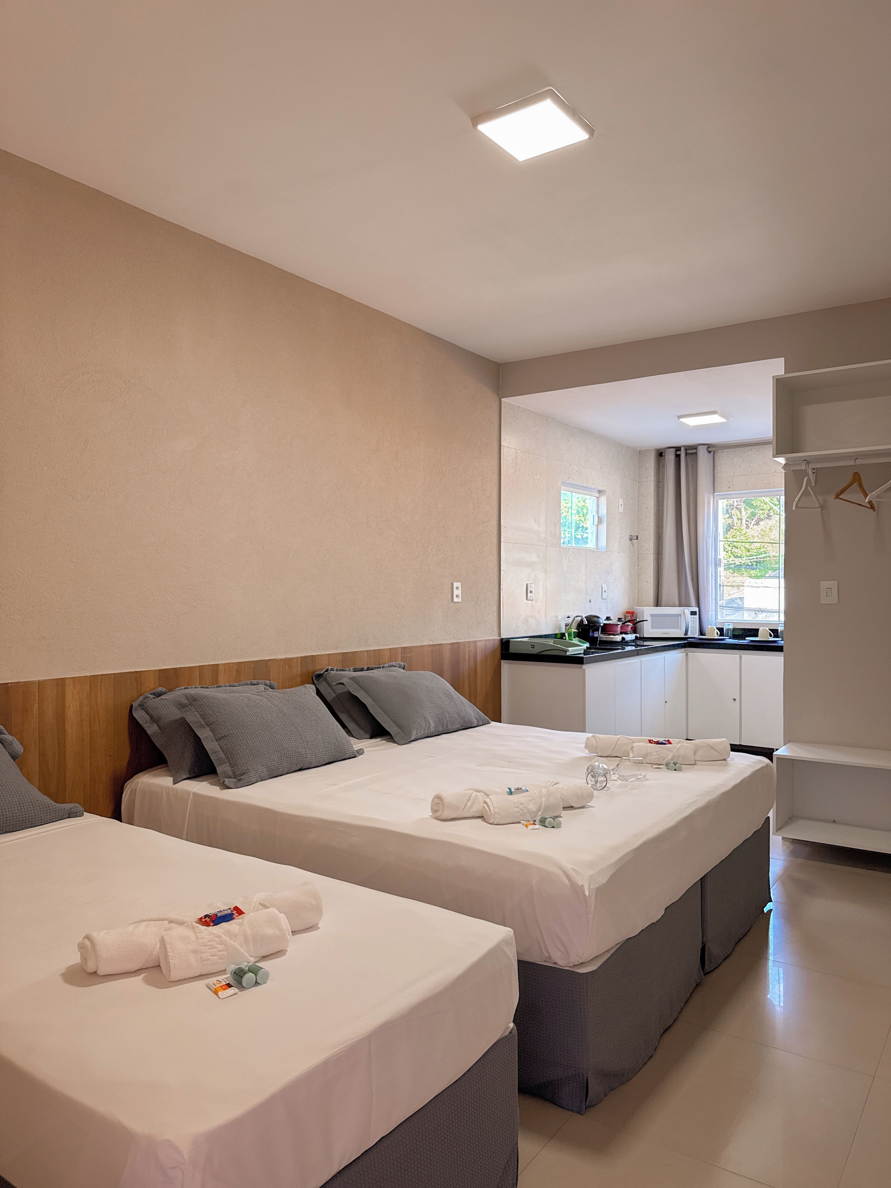 Une chambre d’hôtel avec deux lits, une kitchenette et une salle de bain.
