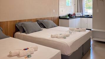 Une chambre d’hôtel avec deux lits, une kitchenette et une salle de bain.