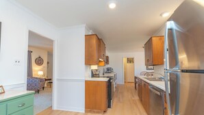 A kitchen with wooden cabinets, a stainless steel refrigerator, and a countertop with a sink.
