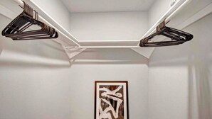 A hallway with a framed abstract artwork on the wall and two black hangers on the ceiling. - Montrose Cheery Studio! Medical Center 09 ★★★★★ (Houston)