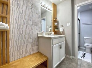 A modern bathroom with a vanity, mirror, and a "CLEAN" mat. - Montrose Cheery Studio! Medical Center 09 ★★★★★ (Houston)