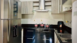 Une cuisine équipée d’appareils électroménagers en acier inoxydable, de meubles en bois et d’une cuisinière à gaz.
