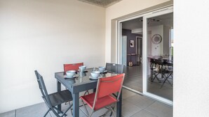 Een eetgedeelte met een tafel voor vier personen, stoelen en een schuifdeur naar een andere kamer.