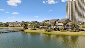 A resort with multiple-story buildings, a small lake, and a bridge.