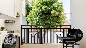 A balcony with a washing machine, a grill, and a tree. - Cozy 2-bedroom apartment in charming Tequila with WiFi, AC (Tequila)