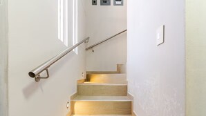 A staircase with a metal handrail and a light fixture on the wall. - Cozy 2-bedroom apartment in charming Tequila with WiFi, AC (Tequila)