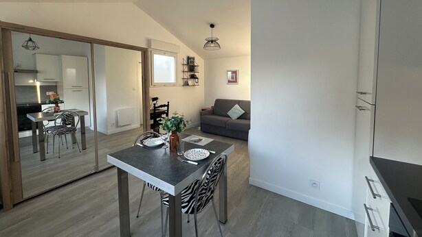 Un apartament modern amb zona de menjador, cuina i espai de sala d'estar.
