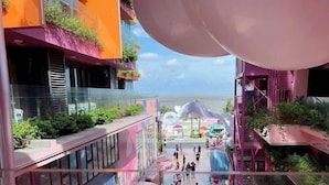 A vibrant indoor public space with a colorful floor design, a central walkway, and a view of the sea. - Hotel Sea View (Hoang Tien)