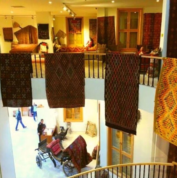 Interior de varios niveles con textiles colgantes, una escalera y una habitación con silla de ruedas.