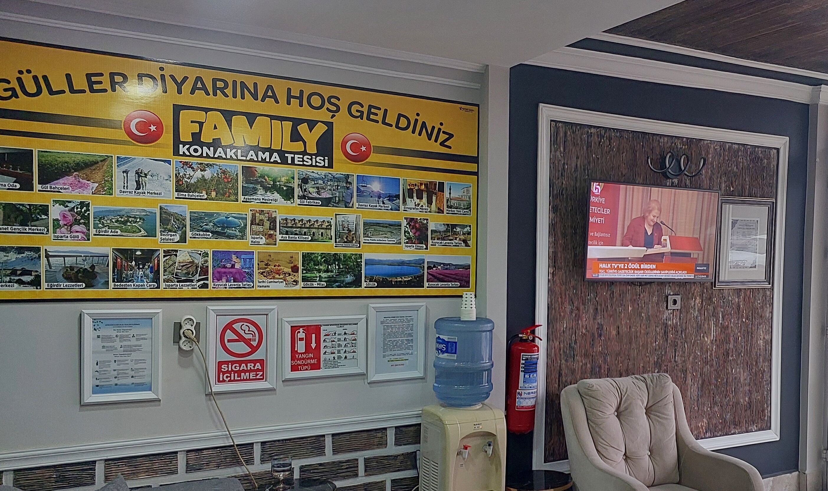A hotel reception area with a large family-themed wall display, a fire extinguisher, and a water dispenser.