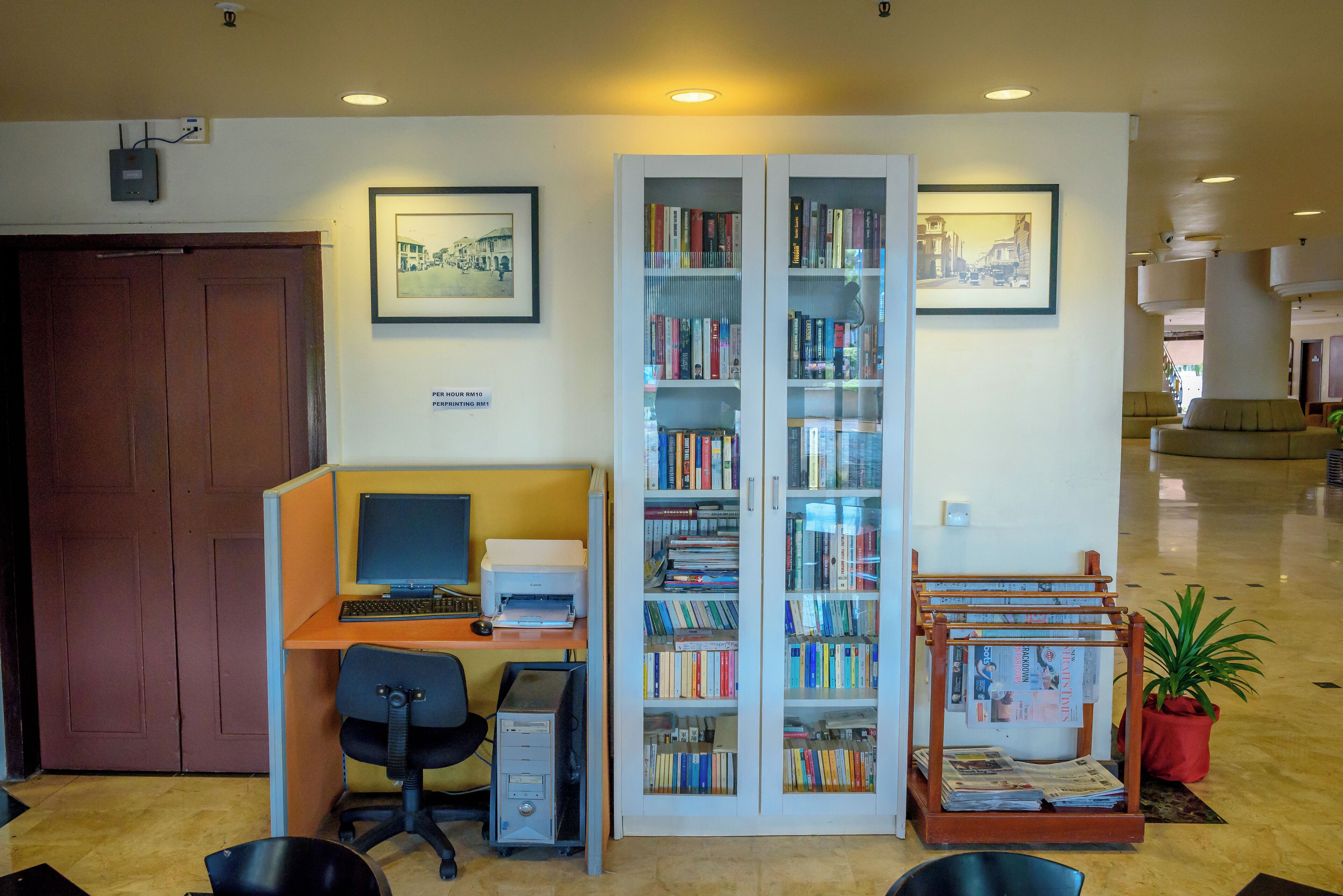 A library with bookshelves, a computer desk, and a printer.