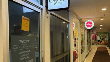 Een salon met een 'Welcome'-bord, informatie over beschikbaarheid en een 'PUSH'-knop bij de deur.