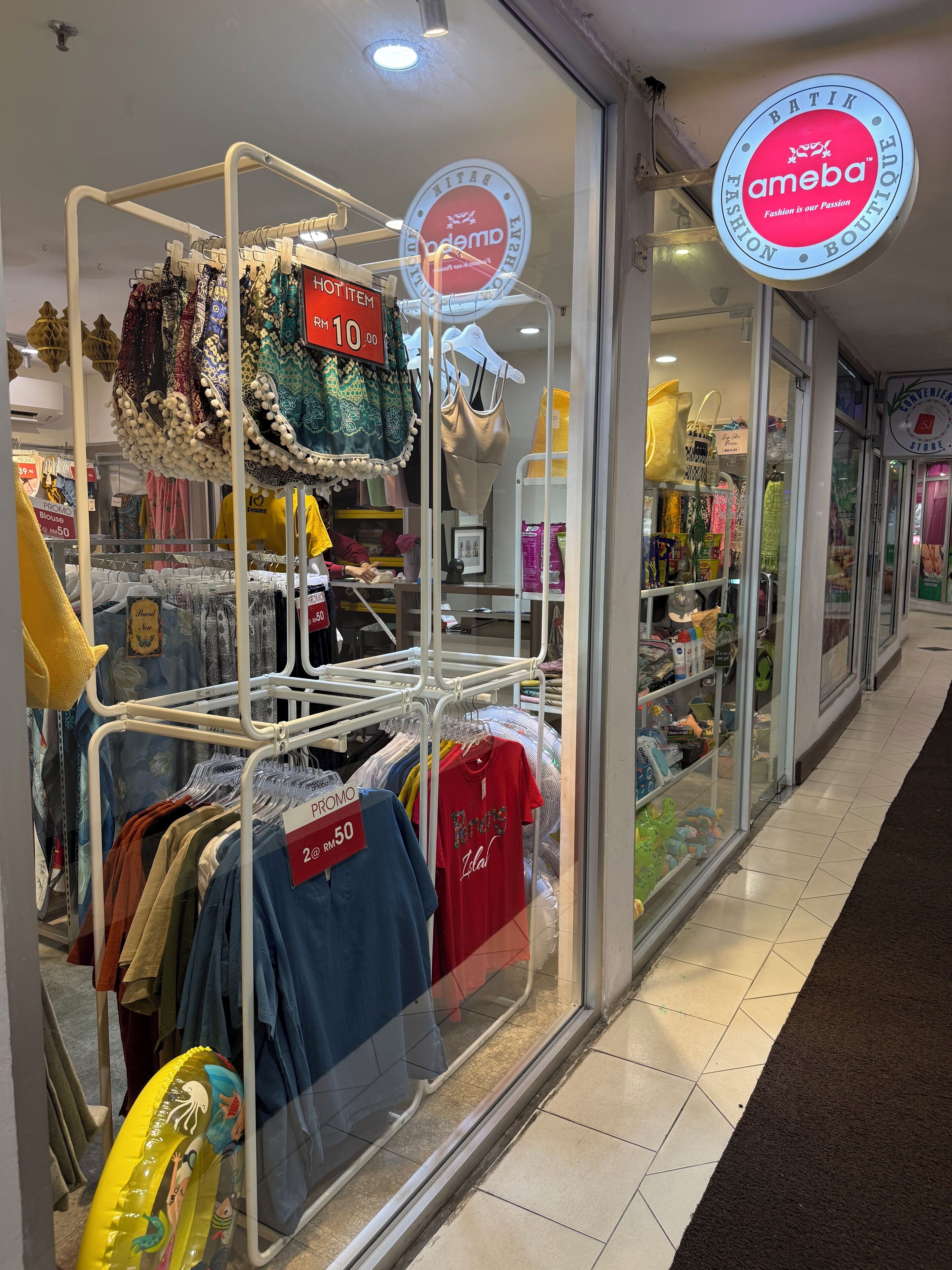 A clothing store with racks of clothes and a sign that reads "Batik Fashion Boutique."