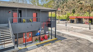 Een gebouw met twee verdiepingen, een balkon, een bord met barbecue en een autowasplaats.
