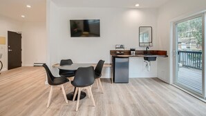 Een moderne keuken met een eetgedeelte, een inbouwoven en een groot raam.