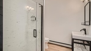 A modern bathroom with a glass shower enclosure, a white sink, and a mirror. - King Room, A/C, Boutique Mtn Motel Idaho Springs (Idaho Springs)