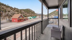 A balcony with a view of a red building labeled "Fun Starts Here" and a green truck in the background. - 2x King Room, A/C, Balcony, Mtn Boutique Motel (Idaho Springs)