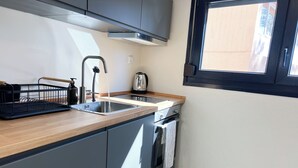 Una cocina moderna con encimera de madera, pileta de acero inoxidable y horno integrado.