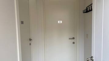 Una porta bianca con il numero 6, una maniglia e una serratura.