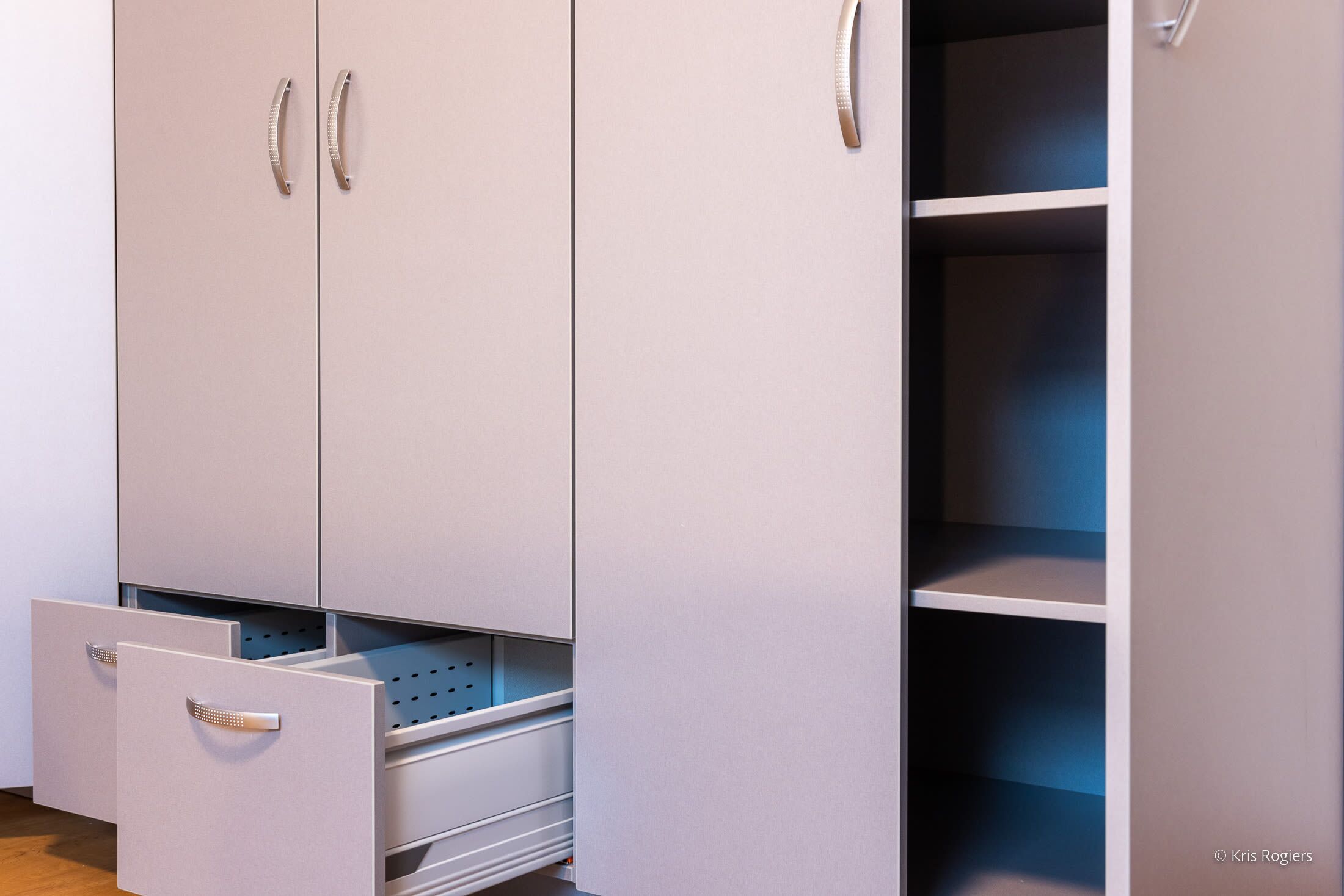 Ein Kleiderschrank mit zwei Türen, einer Schublade und einer Regal-Einheit.
