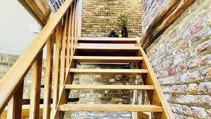 Un escalier en bois avec un mur de briques en arrière-plan.