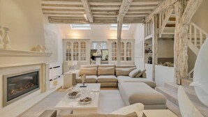 A spacious living room with a fireplace, a large sofa, and a coffee table.