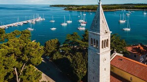 A coastal view with a prominent tower and a marina filled with sailboats. - Al Porto Suites (Novigrad)