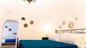 Ein Schlafzimmer mit Bett, Nachttisch, Lampe und Wanddekorationen.