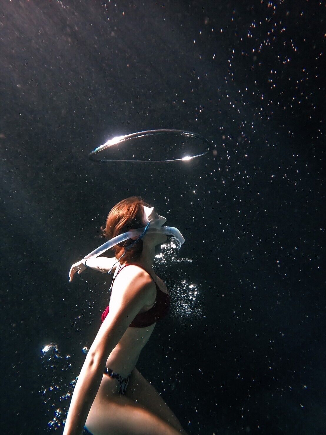 Una persona sott'acqua con maschera e boccaglio, circondata da bolle.