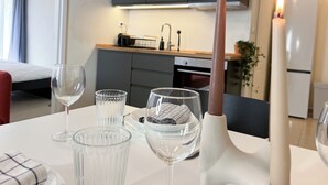 Une cuisine moderne avec des meubles gris, un plan de travail blanc et une bougie allumée sur la table.