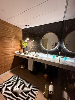 A modern bathroom with a wooden wall, a marble backsplash, and a white vanity. - Our Douro Design 3suites Jacuzzi Pool Flat (Cinfães)