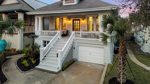 A two-story house with a front porch, a garage, and a well-maintained garden.