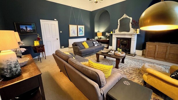 A living room with a sofa, coffee table, and fireplace.