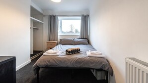 A bedroom with a bed, a window with curtains, a radiator, and a wardrobe. - Central Flat, Off-Road Parking (Shirley)