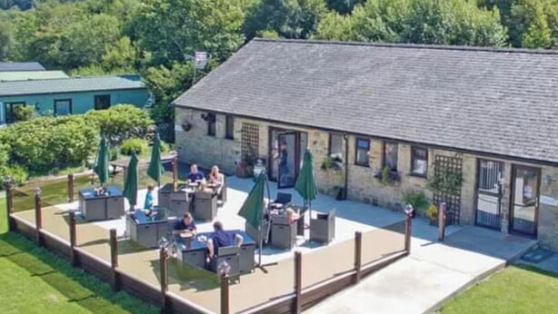 Un bâtiment doté d’un patio comprenant un espace extérieur aménagé avec des sièges et des parasols.