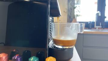 A coffee machine dispensing coffee into a glass cup.