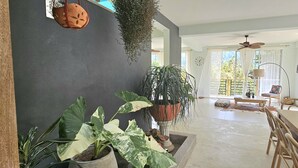A spacious living area with a large dining table, multiple chairs, a ceiling fan, and various potted plants. - Casa Li Tayrona (Santa Marta)