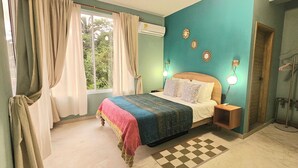 A bedroom with a bed, curtains, an air conditioner, wall decor, and a checkered rug. - Casa Li Tayrona (Santa Marta)