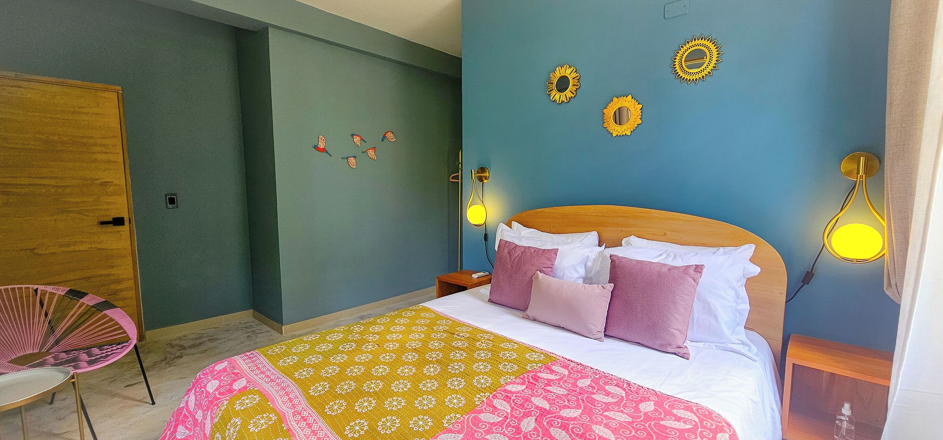 Una camera da letto con un letto, una sedia, un comodino e decorazioni a parete.