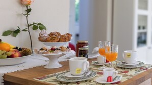 Une table de petit-déjeuner avec des viennoiseries, des fruits et des boissons.