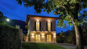 Une maison à deux étages dotée d’un balcon, d’une pelouse bien entretenue et surplombant un paysage montagneux.