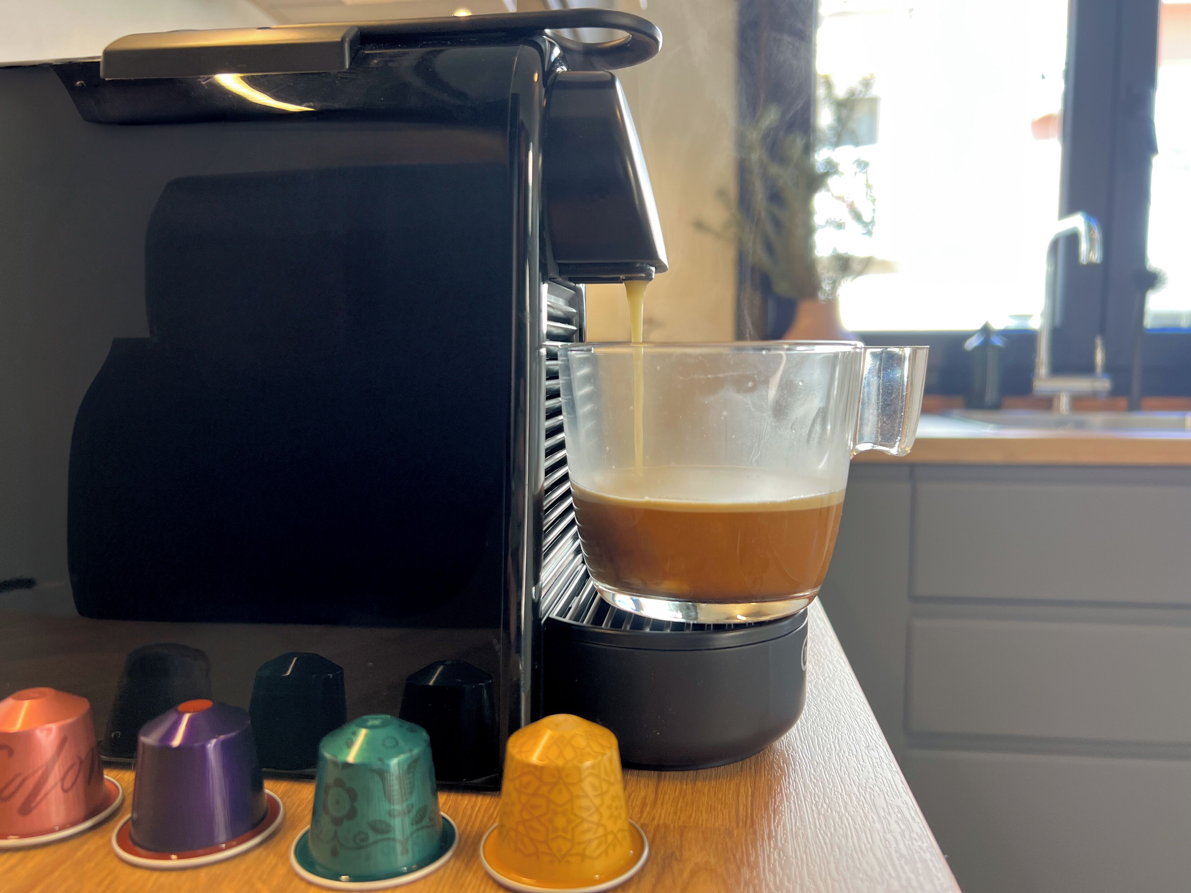 A coffee machine dispensing coffee into a glass cup.