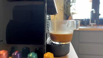 A coffee machine dispensing coffee into a glass cup.