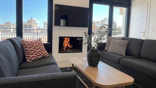 Un salon moderne avec une cheminée, deux canapés et une table basse.